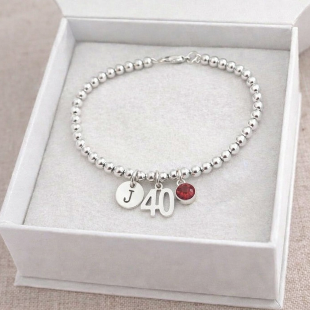 40 charm bracelet with initial and red birthstone detail