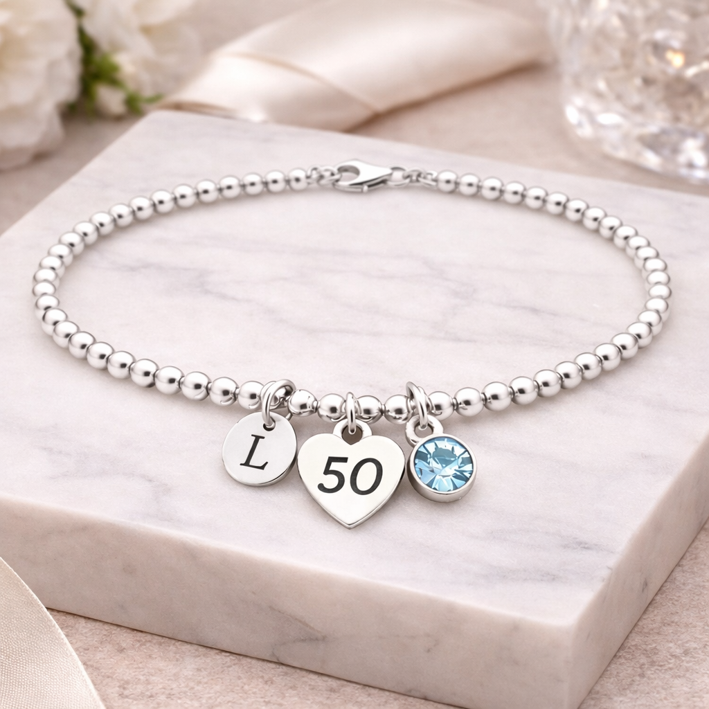 Delicate silver bracelet with personalized initial charm and birthstone accent, perfect 50th birthday keepsake gift