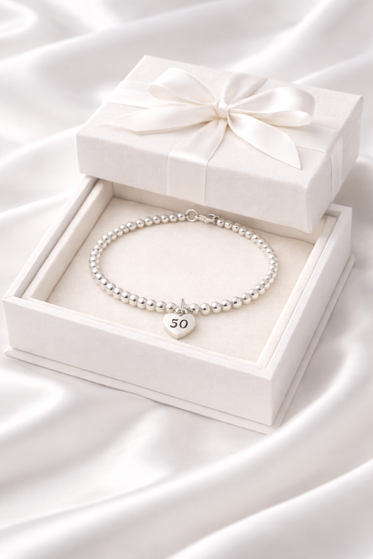 Milestone 50th birthday keepsake bracelet with silver beads and heart charm, presented in a luxury gift box