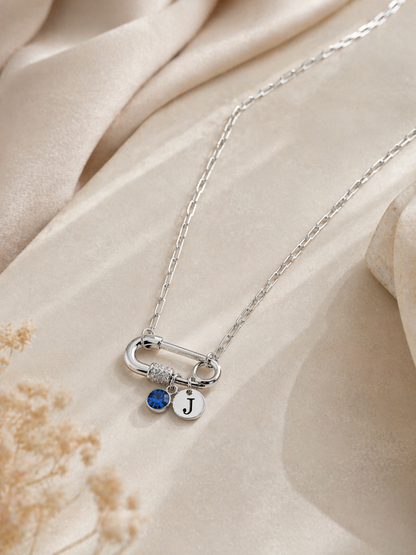 Modern silver paperclip necklace styled on soft neutral background