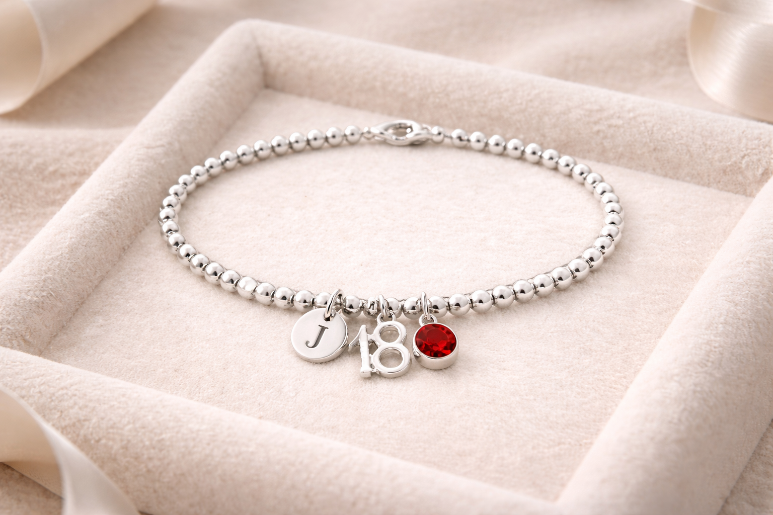 Personalised sterling silver 18th birthday bracelet with initial charm and number 18 pendant.