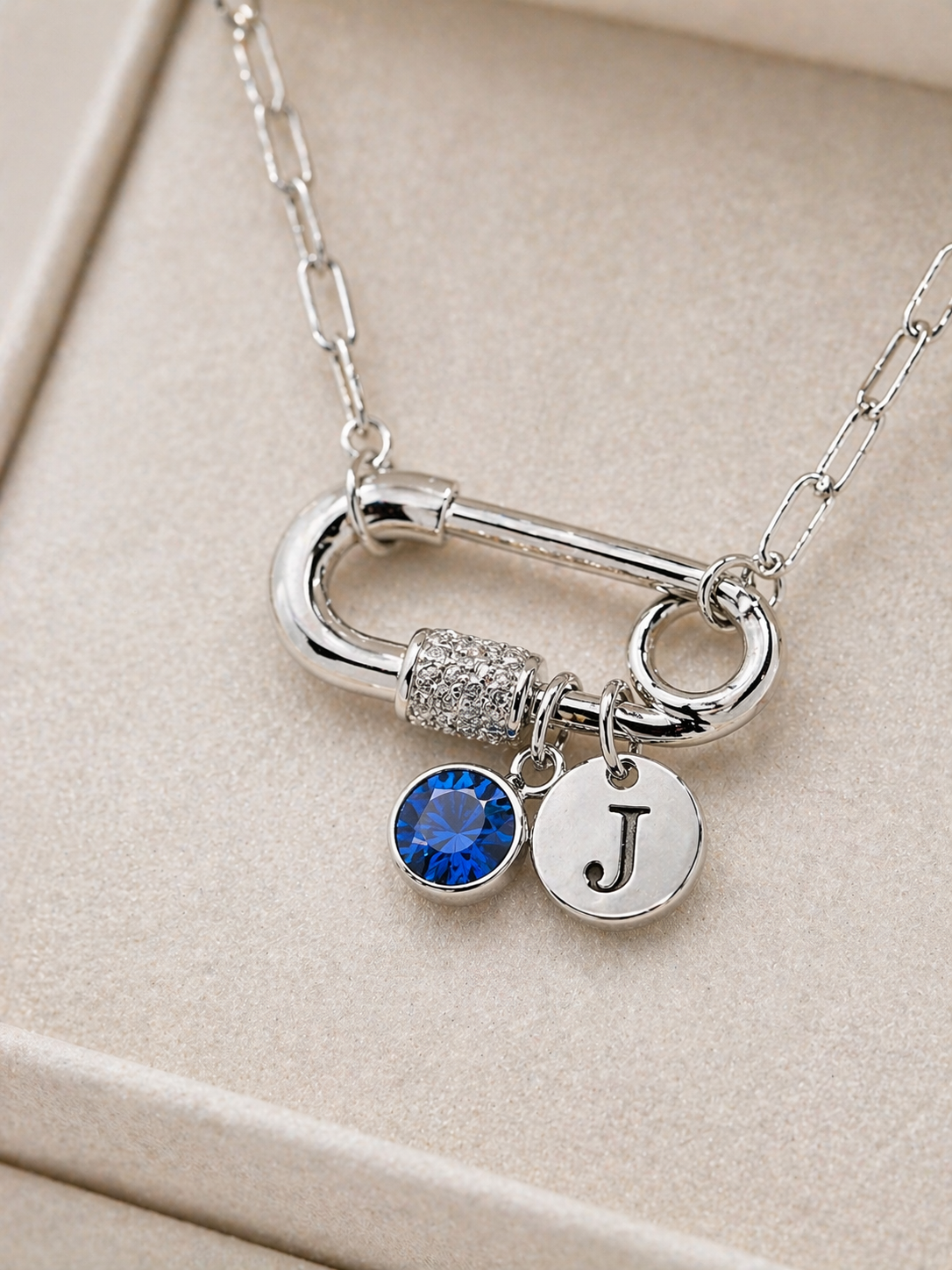 silver paperclip necklace featuring an initial charm and birthstone