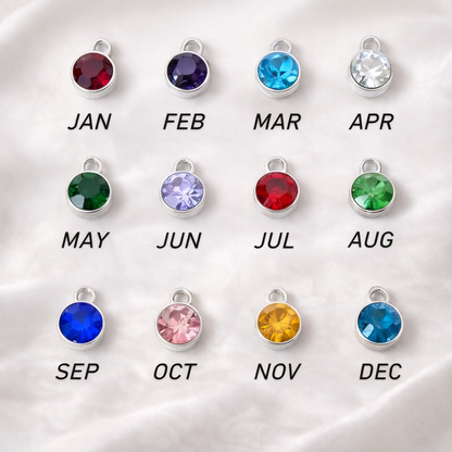  twelve birthstone charms with corresponding months on a white background